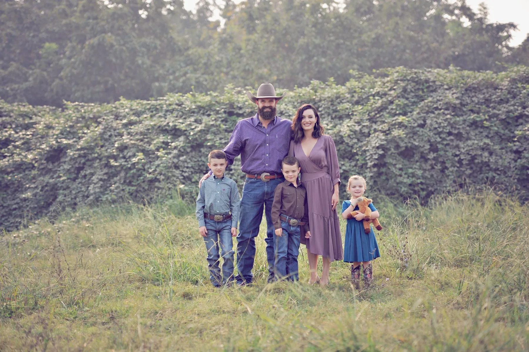 Dr. Kaci with her husband Dustin and their three children in a green field
